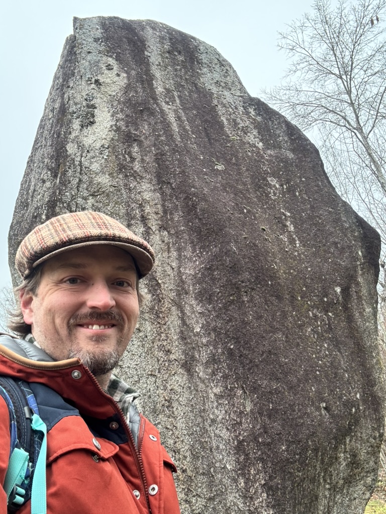 Charles Zimbrick-Rogers, a Jungian Analyst, in the Philadelphia area, with an office in Narberth, PA, standing with the Menhirs of Clendy